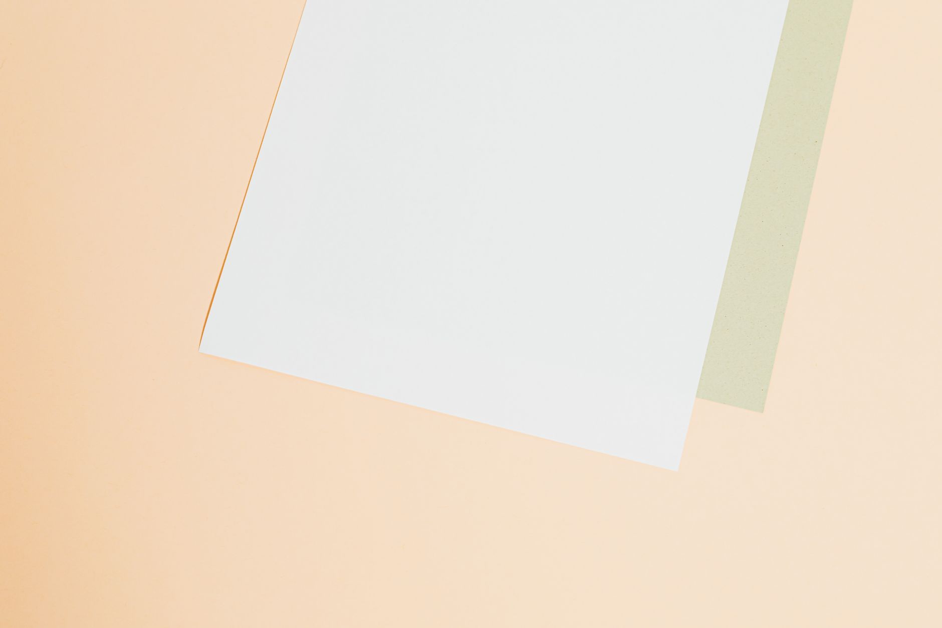 Due fogli di carta bianca su sfondo pastello morbido, spazio per testo o design